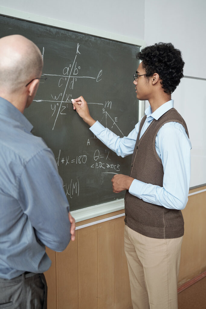 A teacher and student at a black board